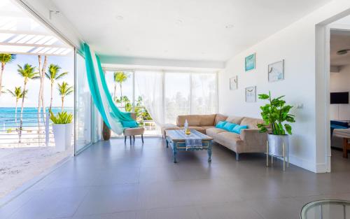 a living room with a couch and a table at Dream Punta Cana Beachfront Apartment - 4-Bedroom Penthouse with Rooftop BBQ & Ocean Views in Punta Cana