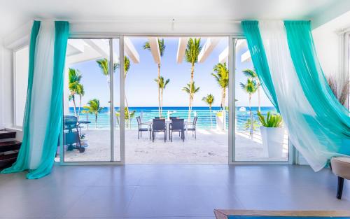 a living room with a view of the beach at Dream Punta Cana Beachfront Apartment - 4-Bedroom Penthouse with Rooftop BBQ & Ocean Views in Punta Cana