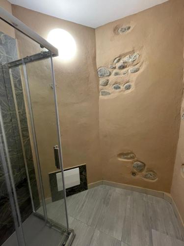 a bathroom with a shower with rocks on the wall at Villa Maria in Occhieppo Inferiore
