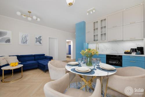 une cuisine et un salon avec une table et des chaises dans l'établissement Seaside Apartamenty Ku Morzu Sianożęty 150m to the beach, swimming pool, à Sianożęty