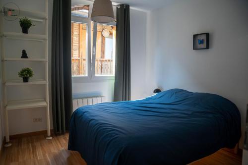 une chambre avec un lit bleu et une fenêtre dans l'établissement Appartement spacieux Neudorf, Strasbourg, à Strasbourg
