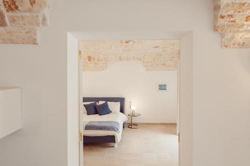 a bedroom with a bed and a brick wall at Le Luci del Borgo B&B in Sammichele di Bari