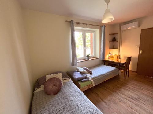 a bedroom with a bed and a window and a desk at Happy Bison - A 5 Bedroom House With A Garden in Białowieża