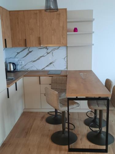 a small kitchen with a wooden table and chairs at Eagles Locus Apartments in Ulcinj