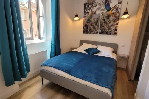 une chambre avec un lit avec une couverture bleue dans l'établissement 06AN - Beautiful apartment in the heart of Old Antibes, à Antibes