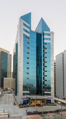 a group of tall glass buildings in a city at Golden Tulip Media Hotel in Dubai