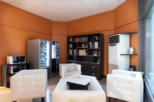 a living room with two white chairs and a table at B&B Hotel Como City Center in Como