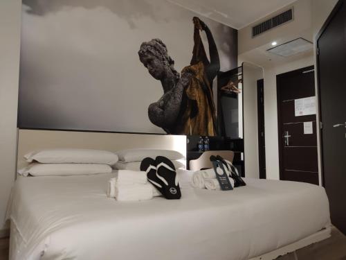 a bedroom with a white bed with shoes on it at B&B Hotel Como City Center in Como