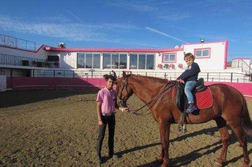 una donna in piedi accanto a un cavallo con un ragazzo sopra di Lusitaurus a Montoito