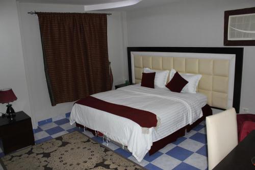 a bedroom with a large bed and a window at شقق آن Ann apartment in Al Jubail