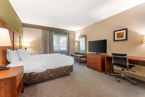 a hotel room with a bed and a desk and a television at Comfort Inn & Suites LaVale - Cumberland in La Vale