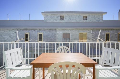 a table and chairs on a balcony with a building at Beach House , Torre Canne - Nemo in Torre Canne