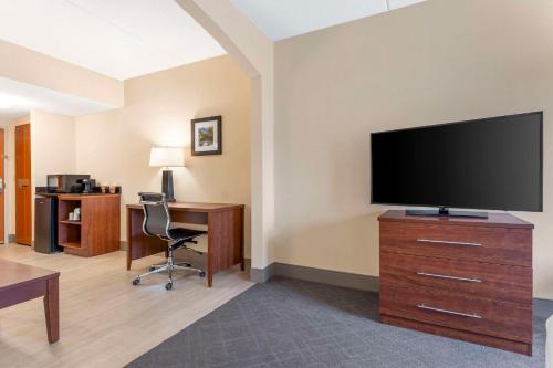 a hotel room with a flat screen tv and a desk at Comfort Inn & Suites LaVale - Cumberland in La Vale