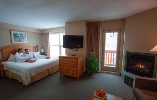 two people laying on a bed in a hotel room at Trickle Creek Lodge in Kimberley