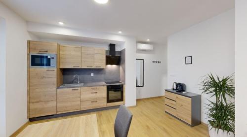 an open kitchen with wooden cabinets and a table at SALAN Apartman Galanta in Galanta