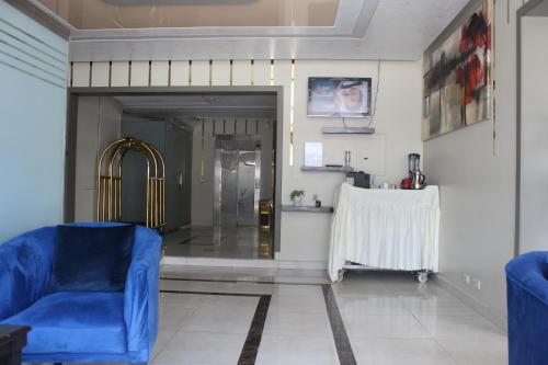 a living room with a blue couch and a table at شقق آن Ann apartment in Al Jubail