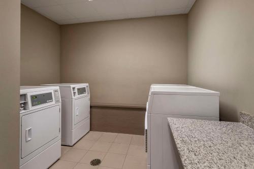 a laundry room with white appliances and a counter at MainStay Suites Bowling Green North in Bowling Green
