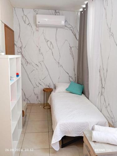 a small room with a bed and a wall at בין העצים in Petaẖ Tiqwa