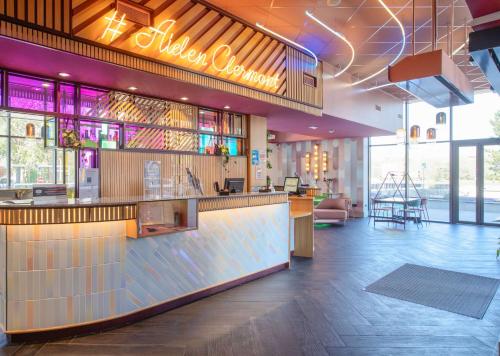 a restaurant with a bar in the middle of a room at Aiden by Best Western Clermont-Ferrand Hotel & Spa in Clermont-Ferrand