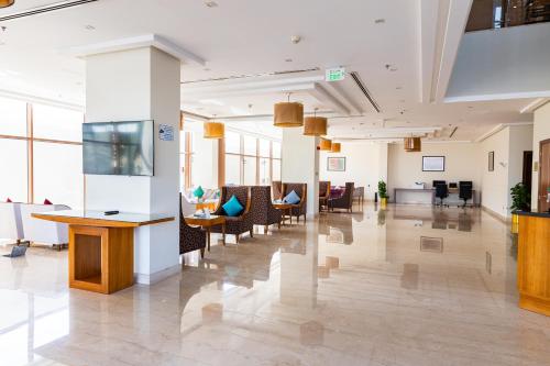 an office lobby with chairs and tables and windows at Wonder Palace Hotel Qatar in Doha