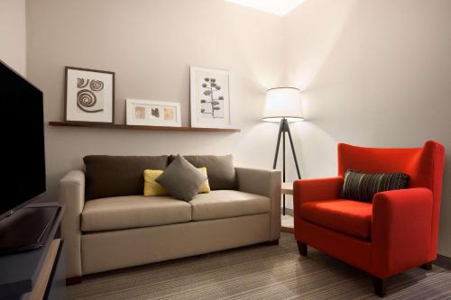 a living room with a couch and a red chair at Country Inn & Suites by Radisson, New Braunfels, TX in New Braunfels