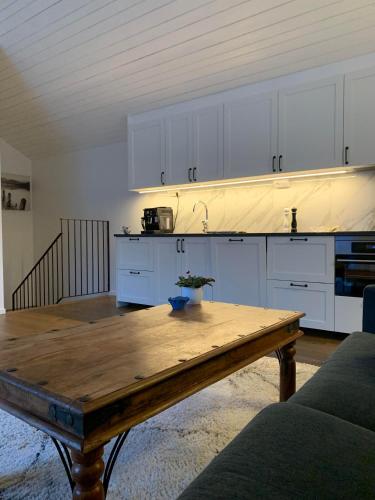 a kitchen with white cabinets and a wooden table at Krok in Värmdö