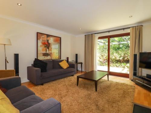 a living room with a couch and a tv at Clematis - Lodge 16 in Wadebridge