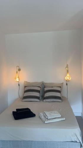 - un lit avec deux lumières et deux serviettes dans l'établissement Studio neuf à 5 min plages et gare, à Vallauris