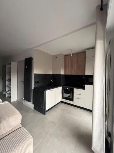 une cuisine avec des armoires blanches et un comptoir noir dans l'établissement Studio neuf à 5 min plages et gare, à Vallauris