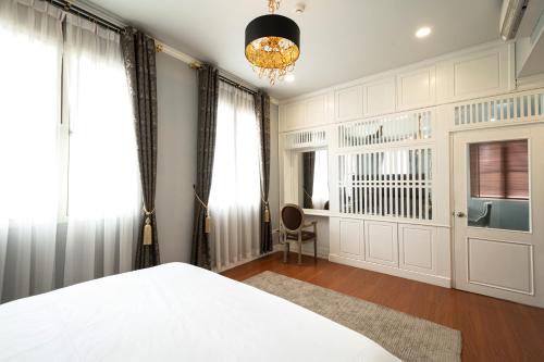 a bedroom with a bed and a window and a chandelier at Niraxay Apartment in Vientiane