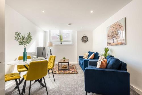 a living room with two blue couches and a table at Smart 1 Bedroom Apartment in Central Rotherham in Rotherham