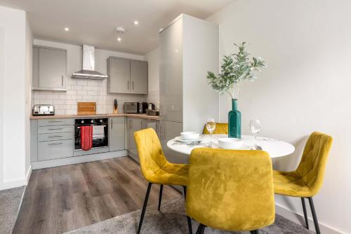 a kitchen with a dining table and yellow chairs at Smart 1 Bedroom Apartment in Central Rotherham in Rotherham