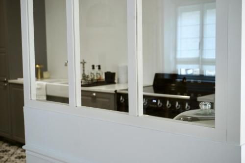 une cuisine blanche avec une cuisinière et un évier dans l'établissement KERVAG Cote émeraude Magnifique Maison à 5 min des plages 3 chb, à Dinard