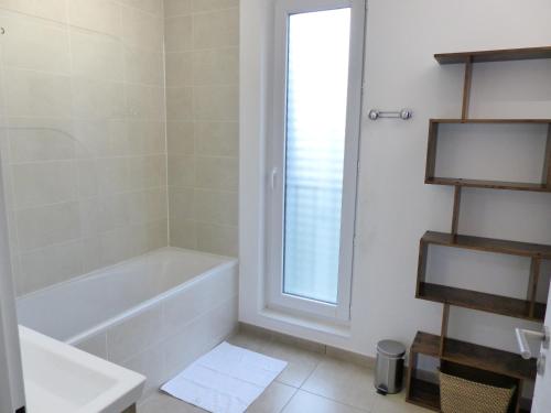 une salle de bain blanche avec une baignoire et un lavabo dans l'établissement Le patio'nnément-T3-Parking, à Nantes