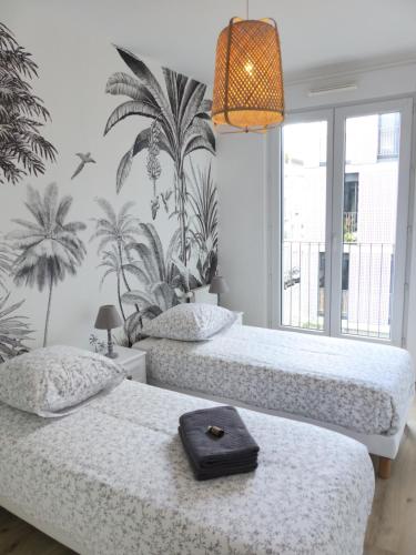 - 2 lits avec un plateau dans une chambre dans l'établissement Le patio'nnément-T3-Parking, à Nantes