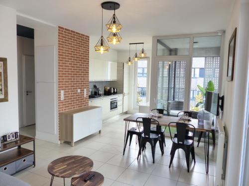 une cuisine et une salle à manger avec une table et des chaises dans l'établissement Le patio'nnément-T3-Parking, à Nantes