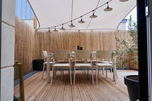 une table à manger et des chaises sur une terrasse en bois dans l'établissement KERVAG Cote émeraude Magnifique Maison à 5 min des plages 3 chb, à Dinard