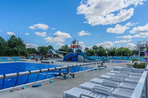 - une piscine avec des chaises et un toboggan dans un complexe dans l'établissement les dunes de contis, à Saint-Julien-en-Born