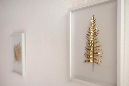 a gold plant in a picture frame on a wall at Bed and Breakfast Ederhof in San Giacomo