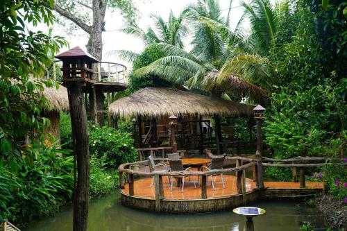 a gazebo with a table and chairs in the water at Bamboo Eco Village in Can Tho