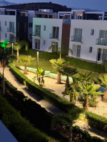 a view of a courtyard with palm trees and buildings at Four Seasons Life - Luxury Beach Resort - Apartments with 2 Bedrooms in Iskele