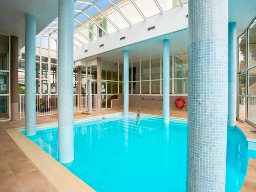 a large pool with blue water in a building at Appartement terrasse centre Saint Martin in Saint-Martin-de-Ré