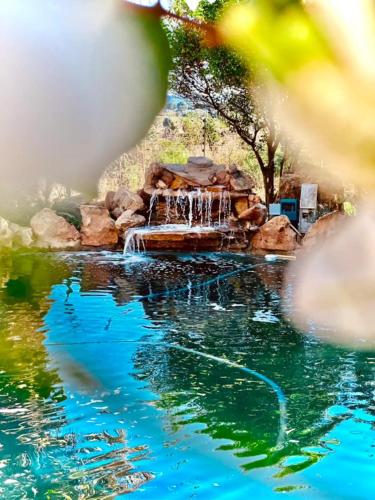 a fountain in the middle of a pond at Guest Suite in Tuscan Farmhouse in Paarl