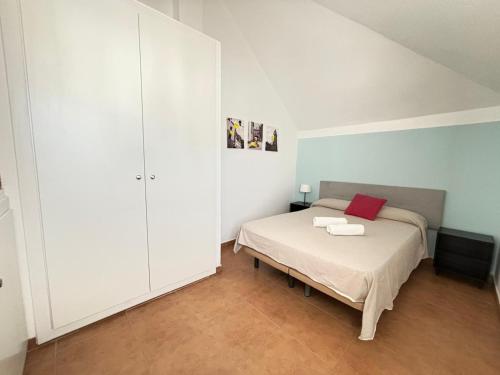 a bedroom with a bed with a red pillow at Azul Zahara in Zahara de los Atunes