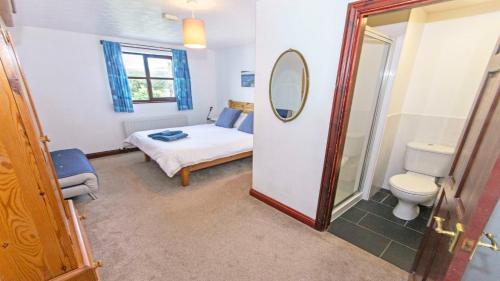 a bedroom with a bed and a toilet and a mirror at Rockham Bay View - Sleeps 6 Mortehoe in Mortehoe