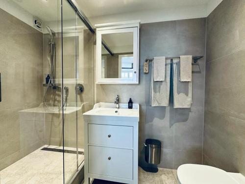 a bathroom with a white sink and a shower at Boutique Hotel Niesenblick - direkt am Thunersee gelegen mit SELF CHECK IN & digitaler Rezeption in Oberhofen am Thunersee