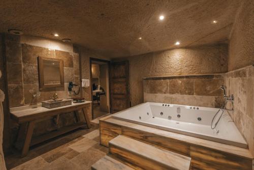 a large bathroom with a tub and a sink at Harem Suites Cappadocia in Uchisar