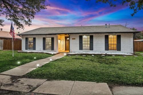a house with a yellow door and a flag at Luxurious 5BR 2BA Holiday Home with Pool, Grill, Sauna & Game Room in The Colony