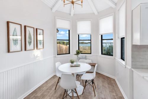a white dining room with a white table and chairs at Lakefront Luxe 6BR 4,5BA Holiday Home with Pool & Hot Tub in Rowlett
