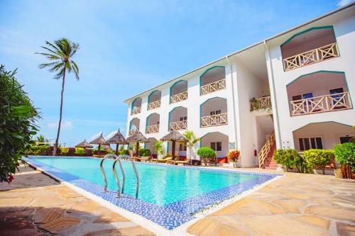 a hotel with a swimming pool in front of a building at AHG Sun Bay Mlilile Beach Hotel in Matemwe